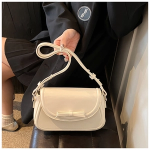 Dettaglio della borsa a tracolla in pelle PU crema con fiocco e design ondulato