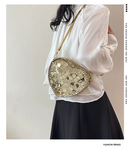 Detail view of champagne gold sequined heart-shaped crossbody bag with chain strap