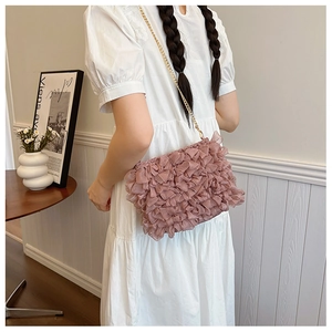 Detail of pink ruffled crossbody bag with mesh layers and fine gold chain strap