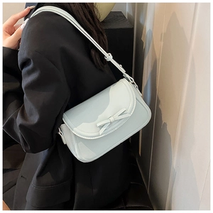 Dettaglio della borsa a tracolla in pelle PU celeste con un elegante fiocco sulla patta