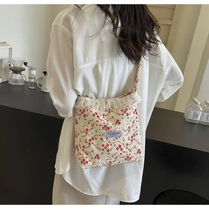 Close-up of floral canvas bag with delicate white lace ruffles and pearl accents