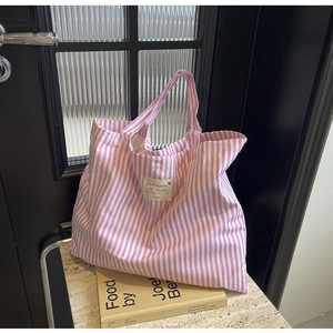 Minimalist pink and white striped canvas tote bag on marble table with a lifestyle background