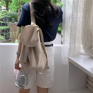 Minimalist beige nylon backpack with drawstring and flap closure for casual summer wear
