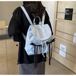 Detail of light blue marble textured backpack with black bow and drawstring closure
