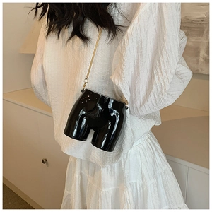 Artistic body-shaped crossbody bag in glossy black finish with a gold chain strap