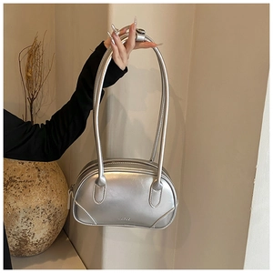 Close-up of silver PU leather handbag with long handles and metallic zipper detail