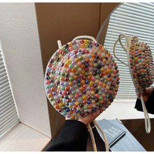 Borsa a tracolla rotonda alla moda con perle iridescenti e tracolla intrecciata bianca