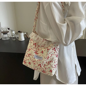 Detail of floral canvas bag with mesh ruffles, pearl accents and fashion label