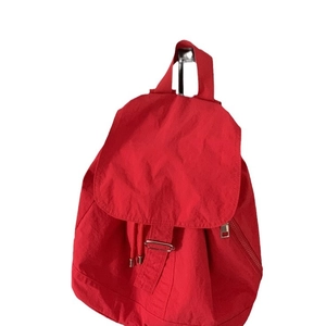 Minimalist red nylon backpack for women with flap drawstring closure and metal side zipper