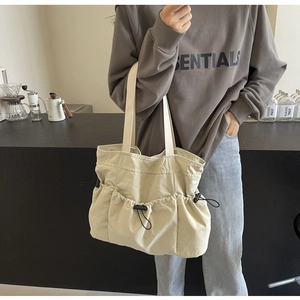 Detail der beigen gewaschenen Stofftasche mit Außentaschen und schwarzem Kordelzug