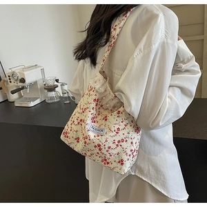 Detail of floral canvas tote bag featuring delicate lace edges and pearl embellishments
