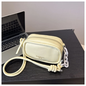 Minimalist light yellow PU crossbody camera bag with white chain detail and knotted strap