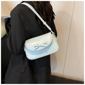 Dettaglio della borsa a tracolla in pelle PU azzurra con fiocco e tracolla regolabile su modella