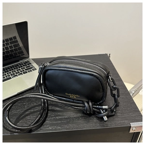 Minimalist black PU leather crossbody bag with gold logo and acrylic chain accessory