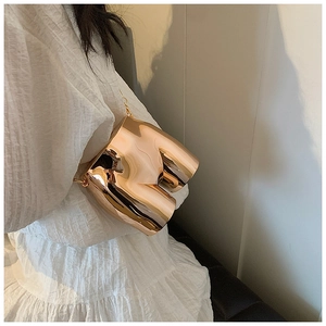 Artistic gold female torso handbag featuring polished mirror finish and delicate chain strap