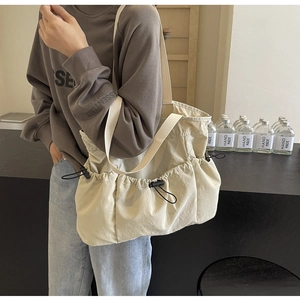 Detailansicht der beigen Nylon-Einkaufstasche mit verstellbarer Kordelzugtasche an der Seite