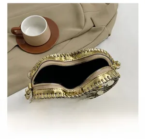 Detail view of heart-shaped sequin crossbody bag with gold and silver glitter texture