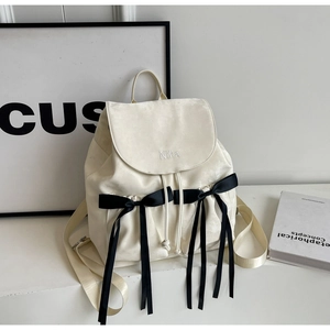 Minimalist off-white velvet backpack with black satin bows and Nika embroidery detail