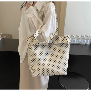 Detailed texture of polka dot canvas bag with ruffle trim and woven brand label