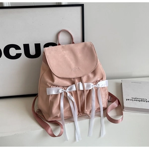 Pink PU leather backpack featuring satin bows and Nilka embroidery in a minimalist setting
