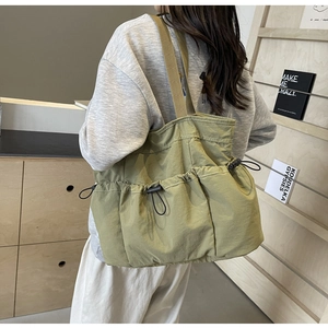 Detail der grünen Nylon-Tasche mit geräumigen doppelten Kordelzug-Fronttaschen