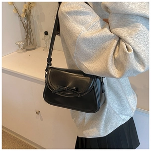 Dettaglio della borsa a tracolla in pelle PU nera con fiocco decorativo e cinturino regolabile