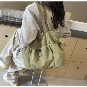 Detail der armee-grünen Nylon-Tragetasche mit Kordelzug-Taschen im Workwear-Stil