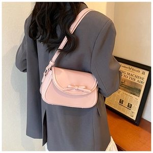 Dettaglio della borsa a tracolla in pelle PU rosa con fiocco decorativo e tracolla