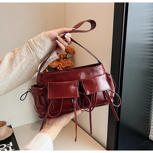 Detailed shot of dark burgundy PU leather shoulder bag with two front pockets and drawstrings