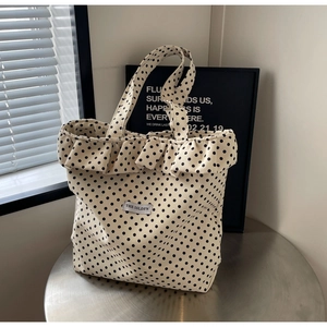 Polka dot canvas tote bag with fashionable ruffle trim and chic brand logo patch