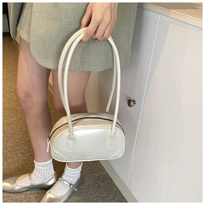 Detailed view of the pearlescent white PU leather shoulder bag with long round handles