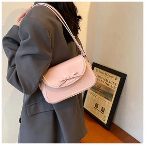 Dettaglio della borsa sottobraccio in pelle PU rosa con fiocco e tracolla regolabile