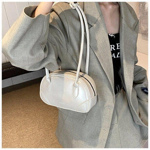 Detail of a cream semi-circle shoulder bag featuring an embossed MICOC logo and glossy finish