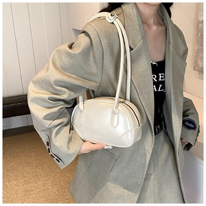 Close-up of pearl white glossy leather underarm bag with sleek dual thin straps