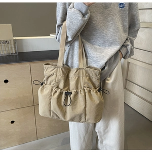 Detailansicht der khakifarbenen Multi-Pocket-Tasche mit Kordelzug und großem Volumen