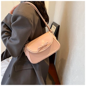 Dettaglio ravvicinato della pelle PU lucida e del fiocco decorativo sulla borsa rosa