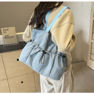 Rückansicht eines Modells mit einer hellblauen Kordelzug-Tasche in einem Raum
