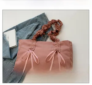 Vue détaillée du sac cabas en tissu rose avec nœuds décoratifs et anses plissées