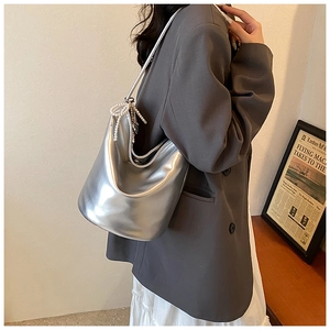 Detail of silver metallic hobo bag with pearl bow charm and pleated edge finish