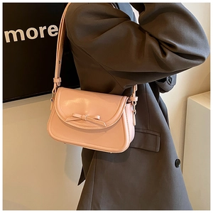 Dettaglio della borsa a tracolla in pelle PU rosa con fiocco decorativo sulla modella
