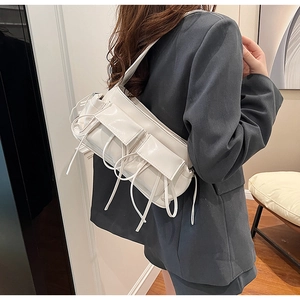 Detail of off-white ruched faux leather shoulder bag with decorative straps and pockets