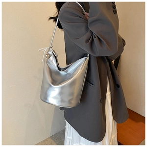 Detail of metallic silver PU leather shoulder bag with pearl bow and heart charm