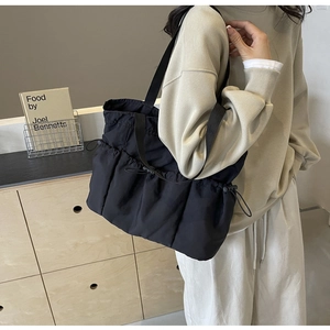 Detail der schwarzen Stofftasche mit verstellbaren Kordelzug-Seitentaschen für Damen