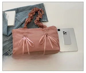 Détail du sac cabas rose en toile avec des poignées plissées et des nœuds de ruban