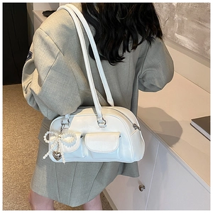 Detailed view of white PU leather shoulder bag with pearl bow and silver heart charm decoration