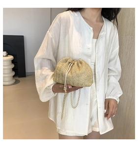 French style straw drawstring crossbody bag with gold chain strap on model