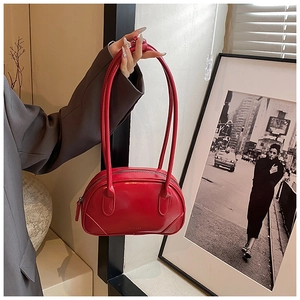 Close-up of red glossy PU leather handbag with sleek handles and brand embossing