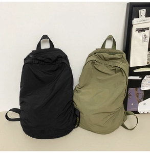 Minimalist nylon backpacks in black and olive green showing smooth matte texture