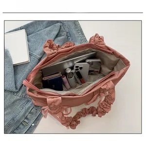 Sac fourre-tout à poignée plissée rose montrant une grande capacité intérieure