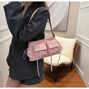 Pink glossy faux leather underarm bag featuring dual pockets and drawstring details
